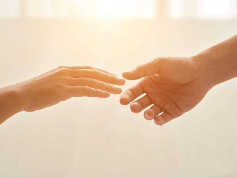Hands of couple reaching for each other